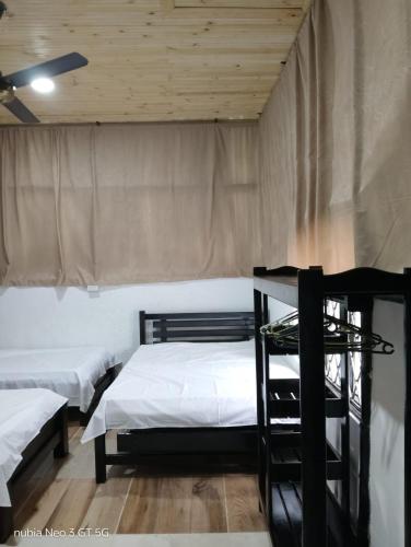 a bedroom with two beds and a wooden ceiling at Finca Agroturística La Sultana in El Espinal