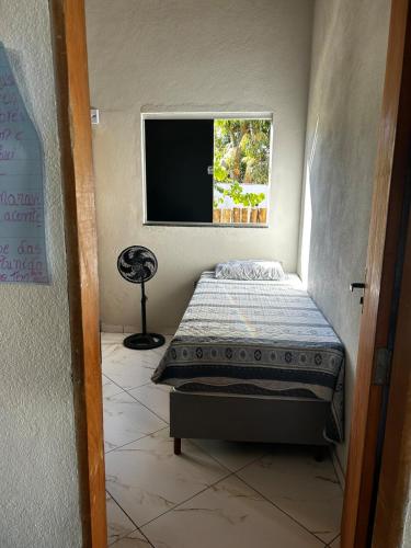 a bedroom with a bed and a television in it at Casa do kell in Itaúnas