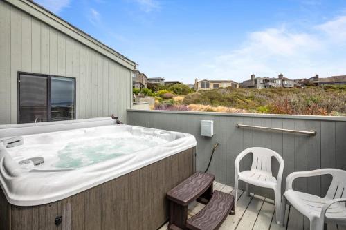 a large bath tub sitting on a deck with chairs at Eagle's Nest in Bodega Bay