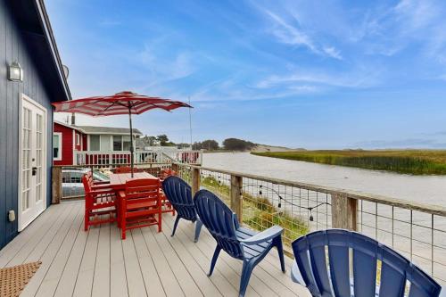 a deck with a table and chairs and an umbrella at Mar-Tiny in Bodega Bay