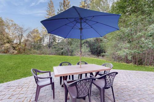 ein Holztisch mit einem blauen Sonnenschirm darüber in der Unterkunft Casa Crotti in Sebastopol