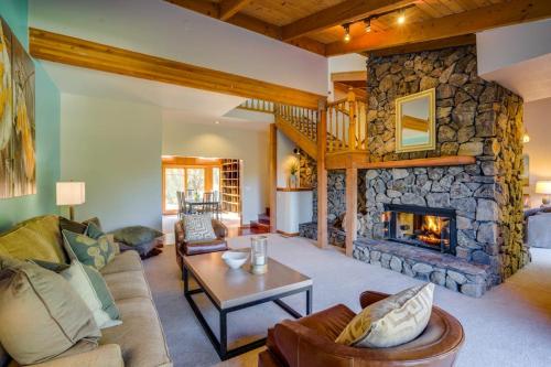 a large living room with a stone fireplace at Leslie Creek House in Mark West Springs