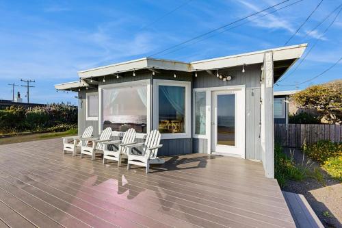 a group of chairs sitting on a deck with a house at Sunset Escape in Bodega Bay