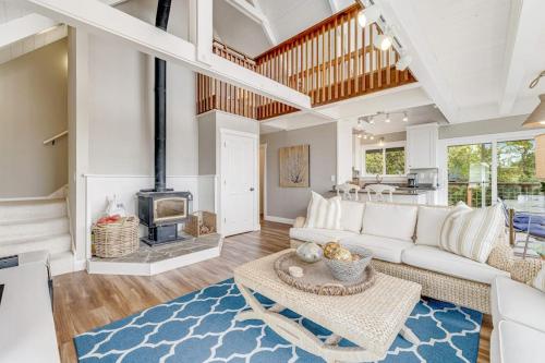 a living room with a white couch and a fireplace at Whaleship Harbor View in Bodega Bay
