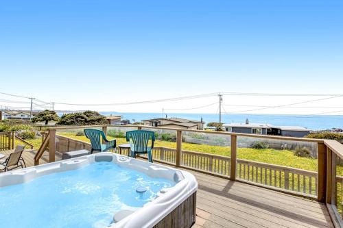 a hot tub on a deck with a view of the ocean at Cozy Carmet Cottage in Bodega Bay