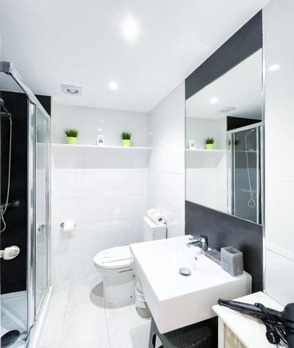a white bathroom with a sink and a toilet at 51 E-scape Home in Corralejo