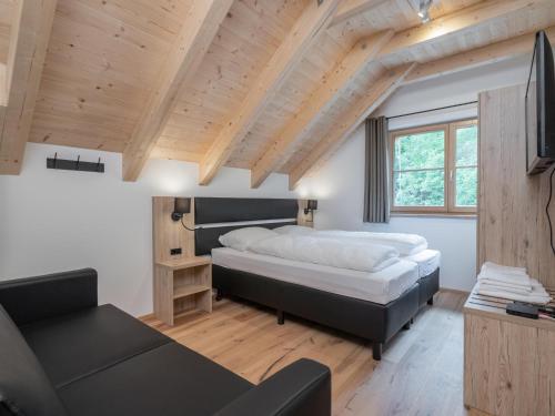 a bedroom with a large bed and a couch at Villa Petra in Donnersbachwald