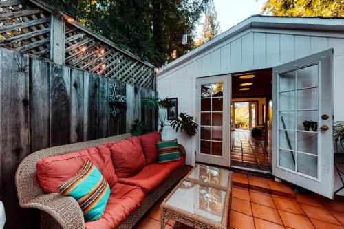 a red couch sitting on a patio with a table at Vineyard Cottage in Guerneville