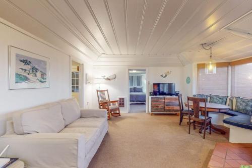 a living room with a white couch and a table at Seaside Cottage in Bodega Bay