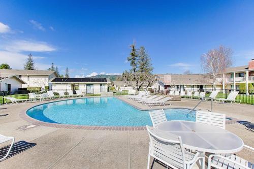 a swimming pool with white chairs and a table at Silverado Resort and Spa 266 & 267 in Napa
