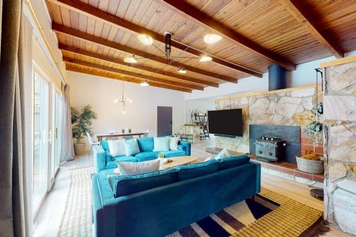 a living room with a blue couch and a fireplace at Riverfront Escape in Monte Rio