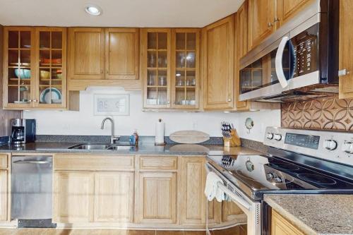 a kitchen with wooden cabinets and stainless steel appliances at Coastal Dream in Bodega Bay