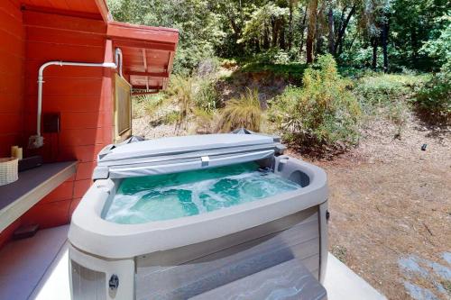a hot tub sitting on the side of a house at Hidden Acres Retreat in Guerneville