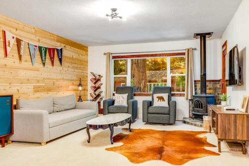 a living room with a couch and chairs and a tv at Caz Cabin 6 in Cazadero