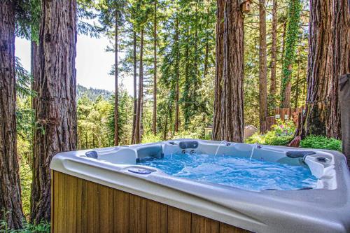 a bath tub in a forest with trees at Sunrise Mountain Retreat in Cazadero