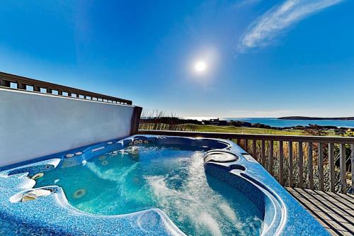 a hot tub on a deck with a view of the ocean at Fairview Grande in Bodega Bay