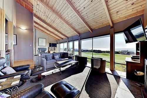 a living room with leather furniture and a large window at Fairview Grande in Bodega Bay