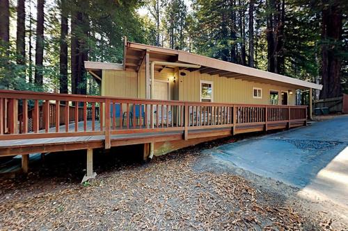 ein Haus mit einer großen Terrasse im Wald in der Unterkunft Wagging Woods in Cazadero