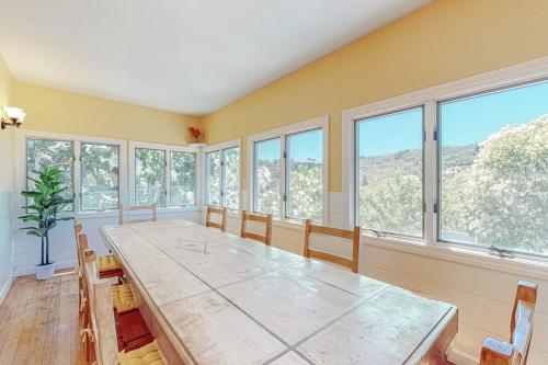 a large dining room with a large table and windows at Dragon Cottage in Healdsburg