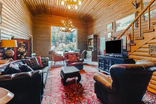 a living room with leather furniture and a television at Antler River Lodge in Guerneville
