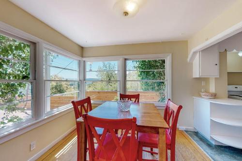 a kitchen with a table and chairs and windows at Rooster Cottage in Healdsburg