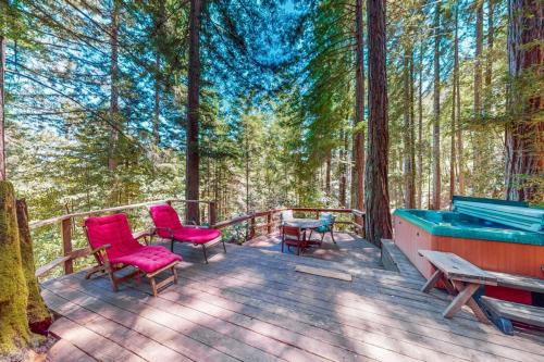 a deck with chairs and a pool in the woods at Dreamcatcher Cottage in Cazadero