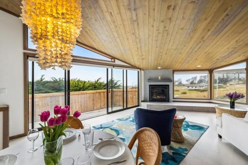 a dining room with a table and chairs and a chandelier at Mar Vista in Bodega Bay