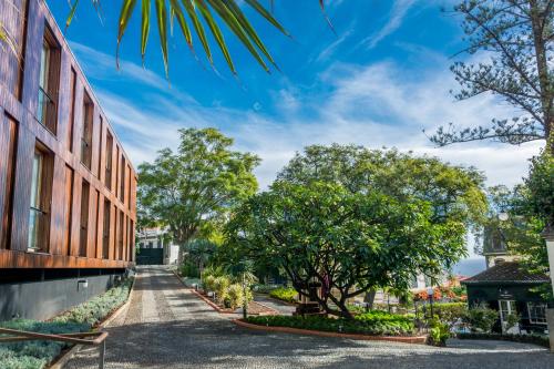 a street in front of a building with trees at ARTS IN Hotel Conde Carvalhal in Funchal