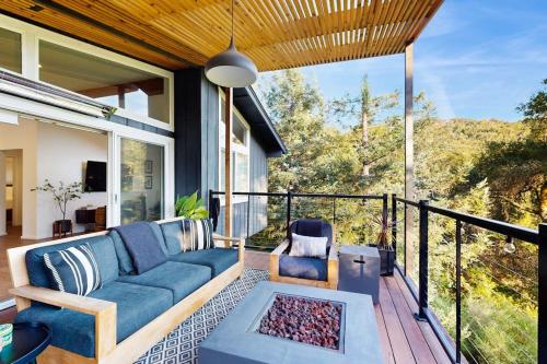a patio with a couch and a chair on a balcony at Rio Lindo River Retreat in Healdsburg
