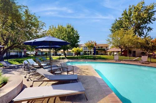 a swimming pool with lounge chairs and an umbrella at Silverado Resort and Spa 288 in Napa
