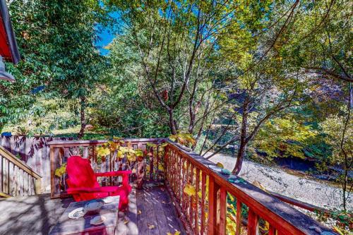 a red chair sitting on a deck with trees at Cazadero Dreams in Cazadero