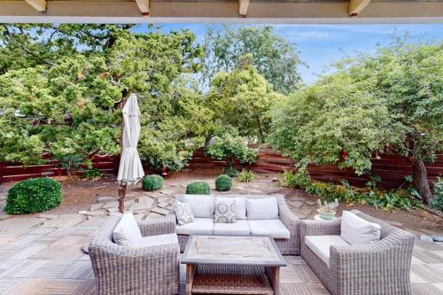 a patio with couches and a table and a umbrella at Jewell Dreams in Santa Rosa