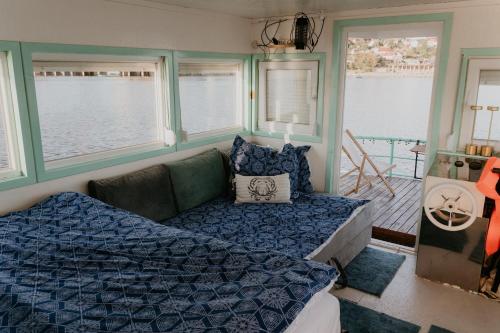 a bedroom with a bed and a couch and windows at Zeleni Biser- Green Pearl in Lukavac