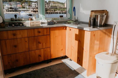 a kitchen with wooden cabinets and a window at Zeleni Biser- Green Pearl in Lukavac