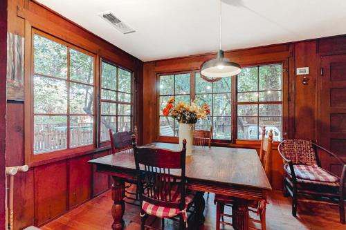 a dining room with a table and chairs and windows at Clearheart Grove in Guerneville
