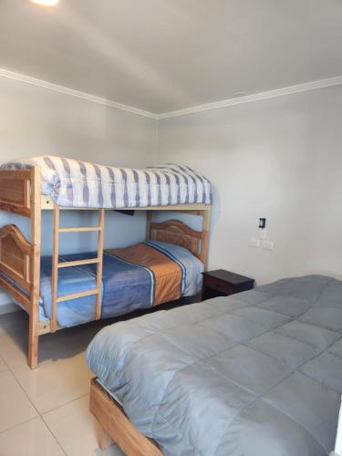 a bedroom with two bunk beds and a bed at Hostal Tamarhugo in Calama