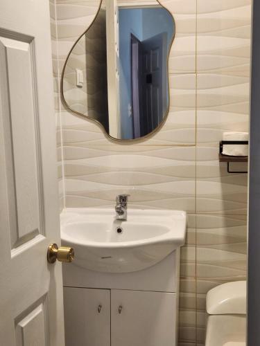 a bathroom with a sink and a mirror at Hostal Tamarhugo in Calama