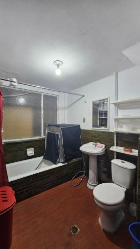 a bathroom with a tub and a toilet and a sink at Zona Sur, Bajo Seguencoma Flat in La Paz