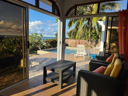 a screened in porch with a view of the ocean at Tekauhivai Lodge in Uturoa
