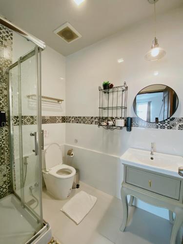 a bathroom with a shower and a toilet and a sink at Sherloft Home & Hostel in Chiang Mai