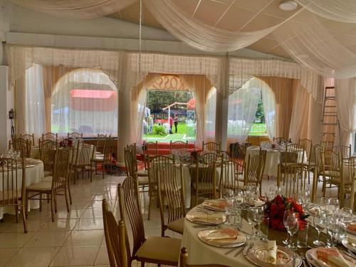 a dining room with tables and chairs and a room with white curtains at Hotel Bellavista in Calca