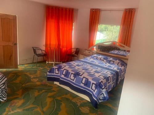 a bedroom with a bed and two windows at Hotel Bellavista in Calca