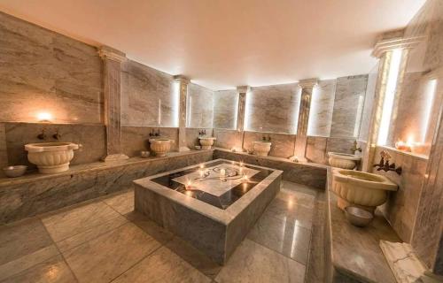 a large bathroom with a large tub and toilets at Erbil Platinum Hotel in Erbil