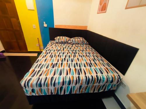a bedroom with a bed with a black headboard at Studio premium -- ap 06 in Diadema