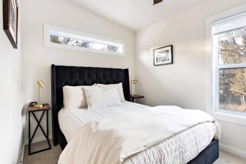 a bedroom with a bed and two windows at The Pinyon - Mountain View Retreat in Carbondale