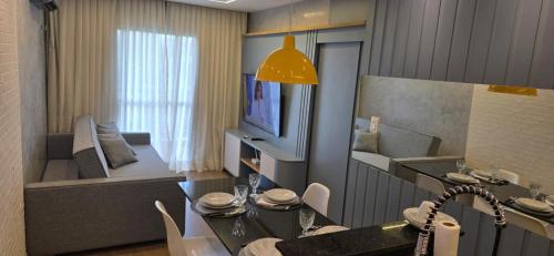 a kitchen and living room with a table and chairs at Vg Sun Cumbuco Beach House in Caucaia