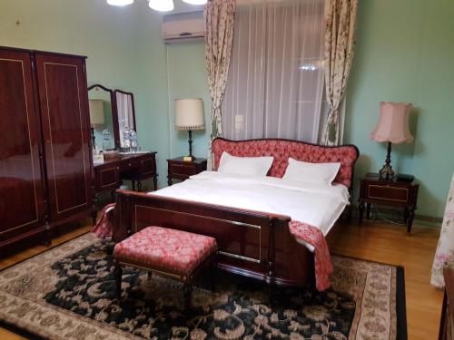 a bedroom with a large bed with a red couch and a chair at Bucharest Boutique Accommodation by Hotels in Bucharest