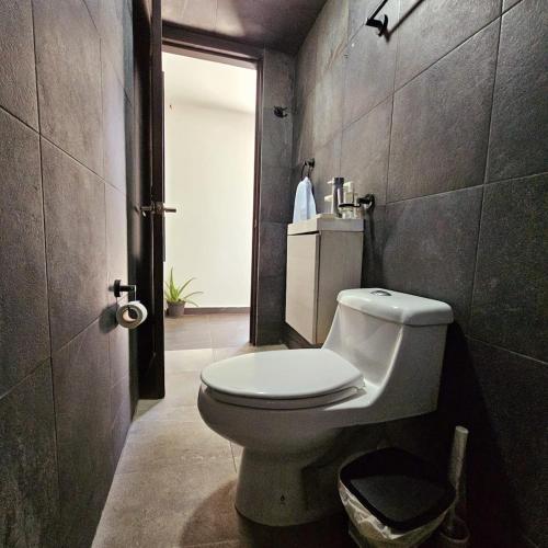 a bathroom with a white toilet in a room at Isabella's Cottage in Cholula