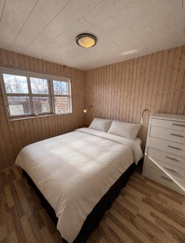 a bedroom with a large white bed in a room at Secret lagoon cabin in Fludir