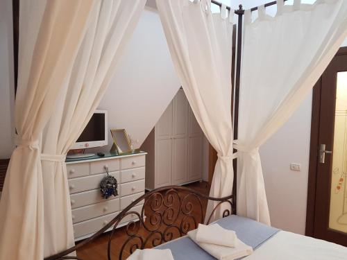 a bedroom with a bed with curtains and a television at Bucharest Boutique Accommodation by Hotels in Bucharest